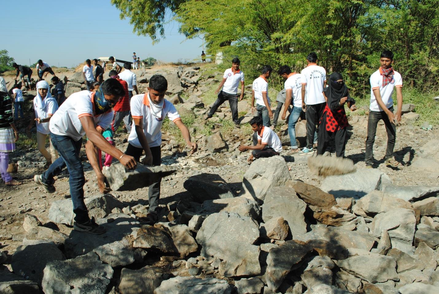 People working around a water-retention structure in Nashik